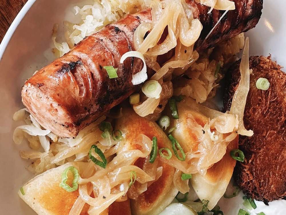 Grilled kielbasa with kraut, pierogi and potato pancake at Wurst Behavior Chicago