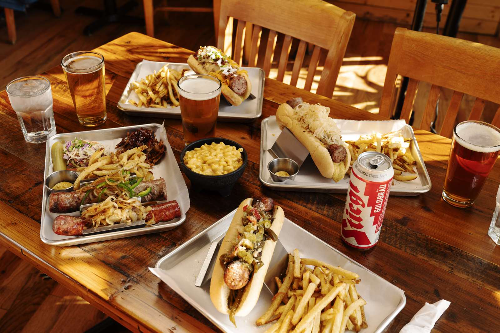 Table of sausages, dogs, mac and cheese and beers at Wurst Behavior