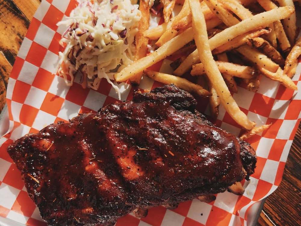 Half slab baby back ribs with house BBQ glaze, coleslaw and fries at Wurst Behavior